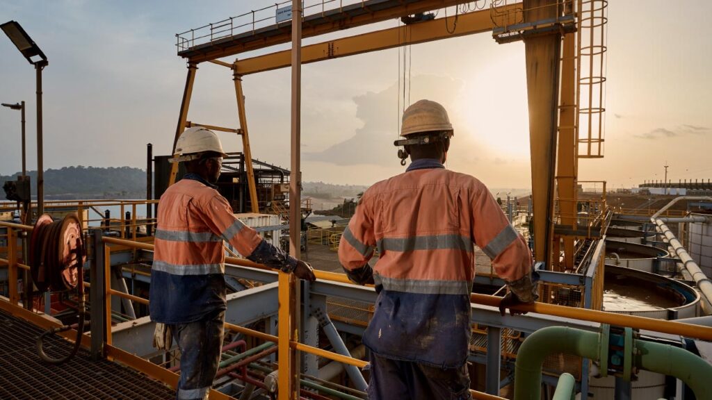 Image of workers look out over the processing plant at Ity, part of the SMO initiative