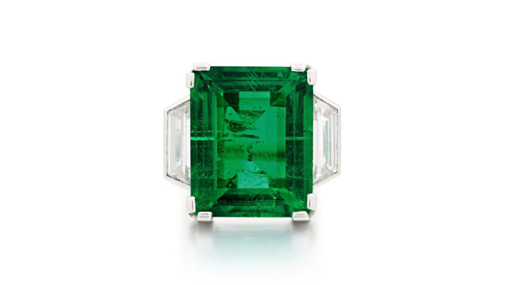 Ring featuring a rectangular step-cut emerald between tapered baguette diamond shoulders at Sotheby's image