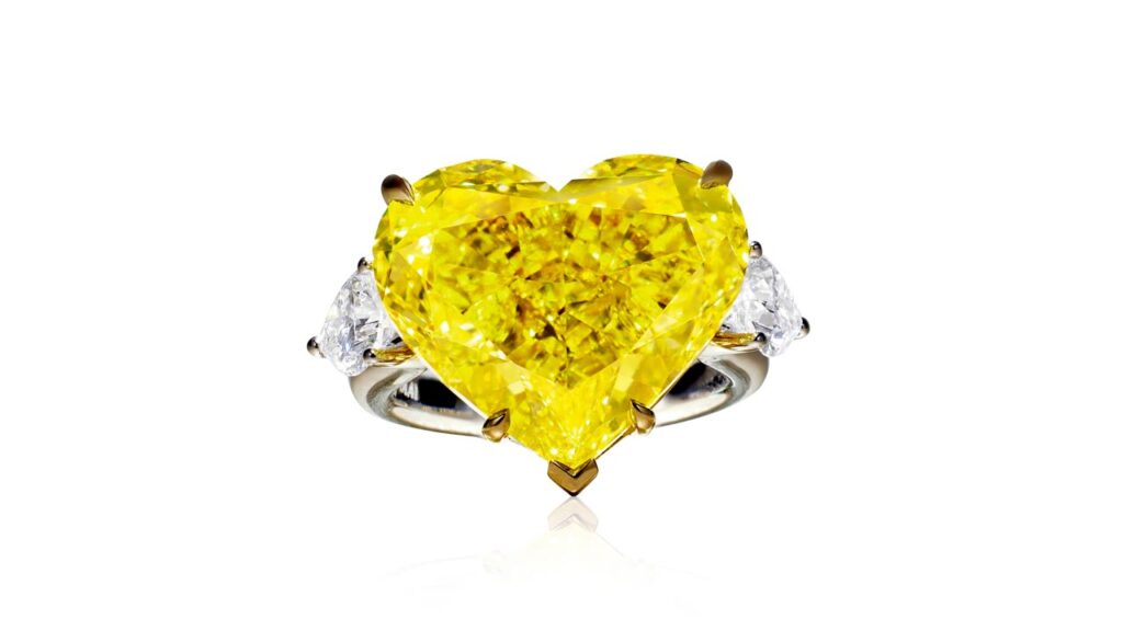 Ring featuring a heart-shaped, fancy-vivid-yellow diamond flanked by D-color diamonds at Poly Auction image