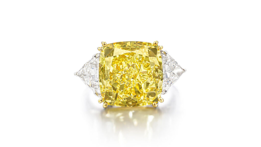 Ring bearing a cushion-shaped, fancy-vivid-yellow, internally flawless diamond, flanked by two triangular diamonds at Sotheby's image