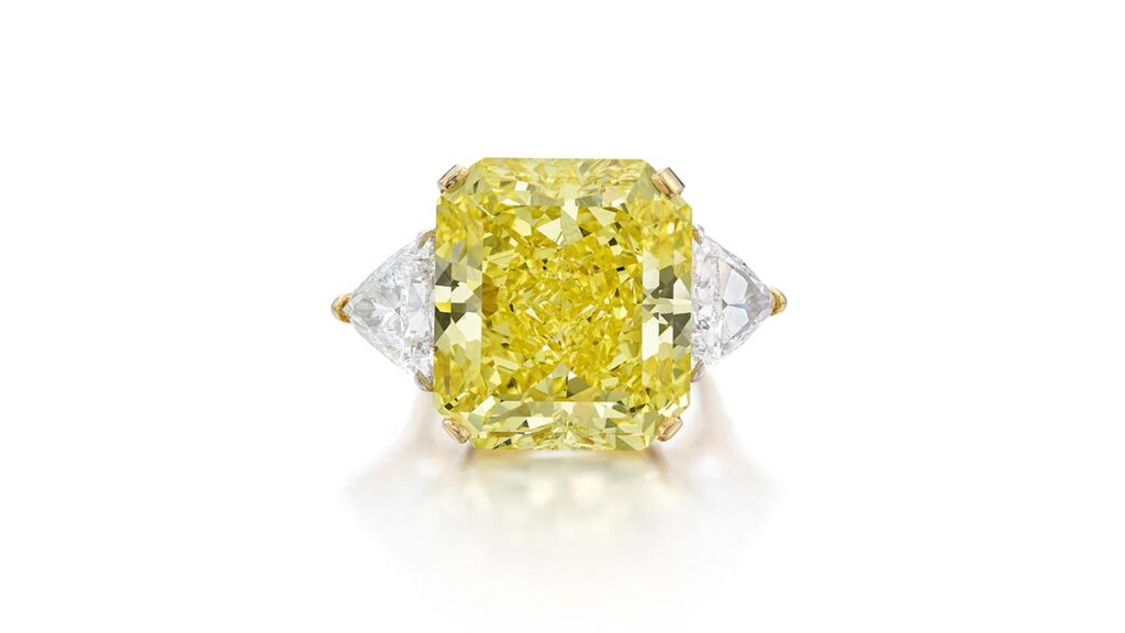 Ring featuring cut-cornered rectangular modified brilliant-cut fancy-vivid-yellow diamond flanked by triangle-shaped, D-color diamonds at Sotheby's image