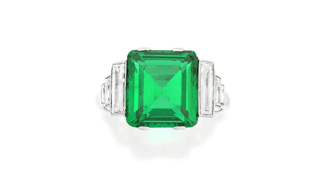 Ring featuring a step-cut Colombian emerald between stepped baguette-cut diamond shoulders at Bonhams image
