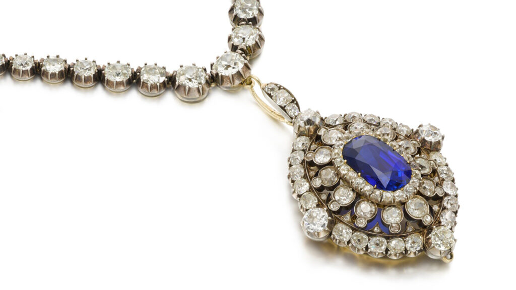 Pendant from the late 19th century bearing an oval-cut, Ceylon sapphire surrounded by cushion-shaped diamonds, with graduated cushion-shaped diamonds in pinched-collet settings along the necklace at Sotheby's image