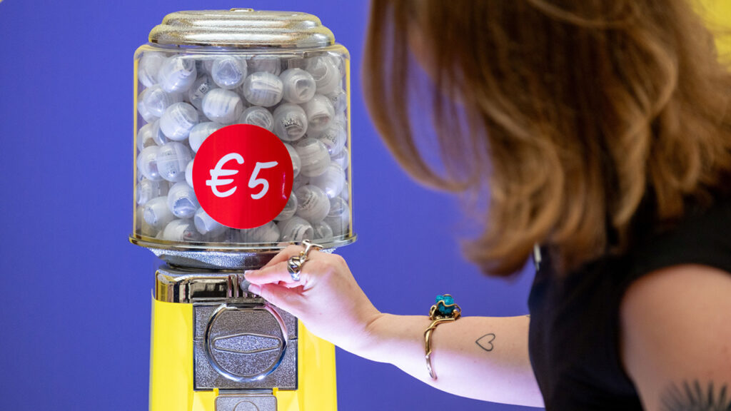 Woman putting a token gumball machine image